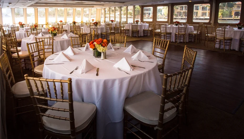 A table with white cloth and gold chairs