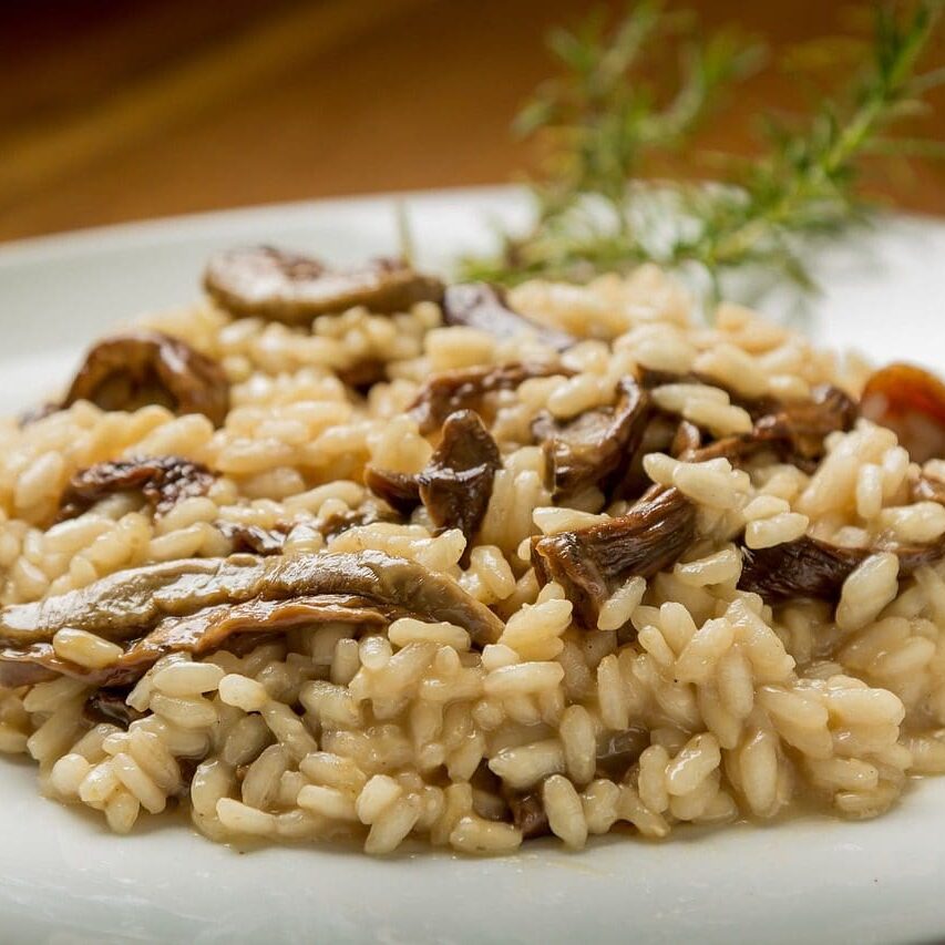 A plate of rice and mushrooms on top of a table.