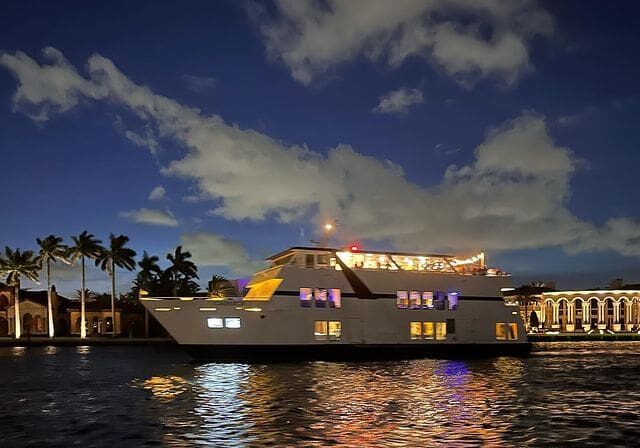 A boat is lit up at night in the water.